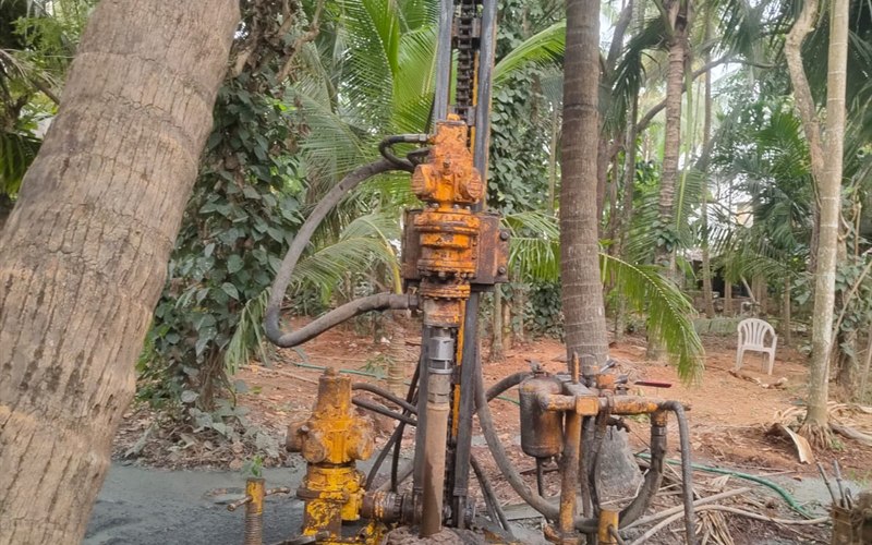 Compact portable micro borewell drilling rig operating inside coconut grove and plantation in Payyannur, Kannur